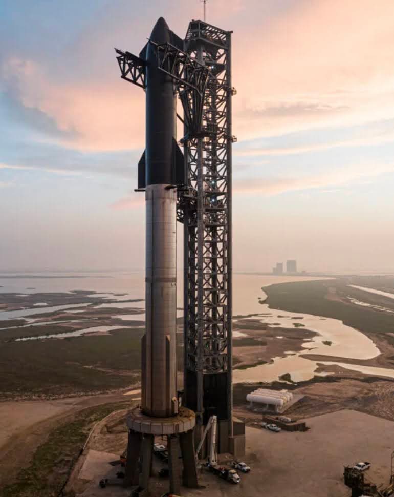 Visitor photo at Starbase beside the Starship launch tower at sunset